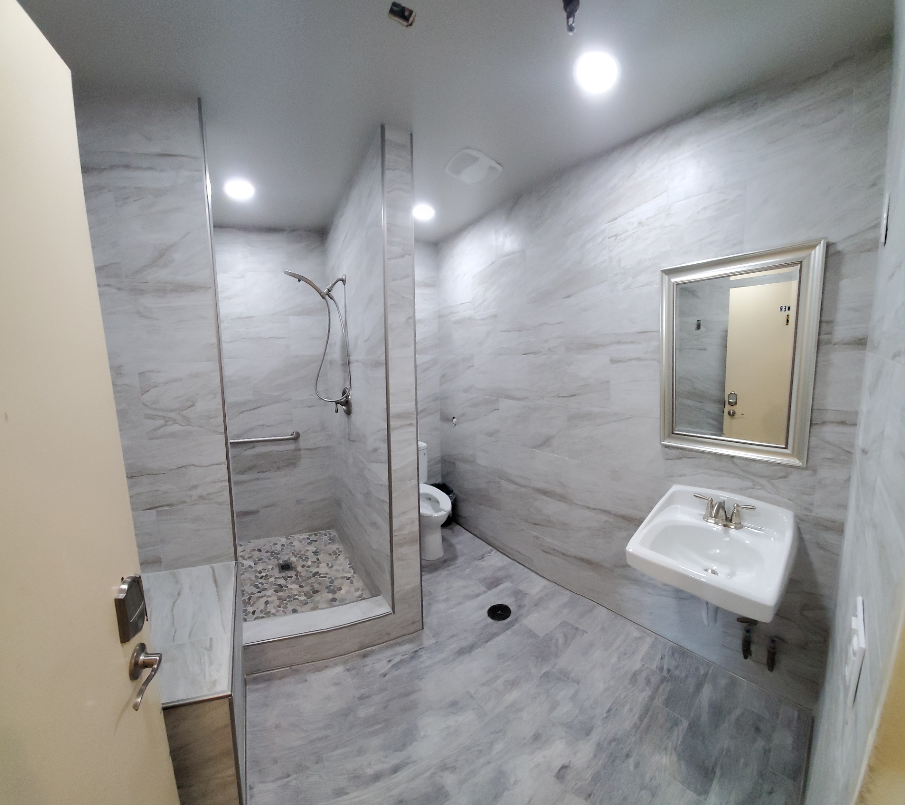 Full guest bathroom renovation with floor-to-ceiling marble-look tile and curbless walk-in shower